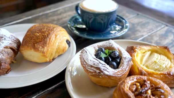 Zoet gebak. Verse smakelijke bakkerij op borden en kopje koffie, Morning sweet food — Stockvideo