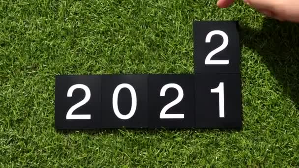 La mulţi ani 2022. 2021-2022 schimbare. Mâna omului schimbă plăcile cu numere — Videoclip de stoc