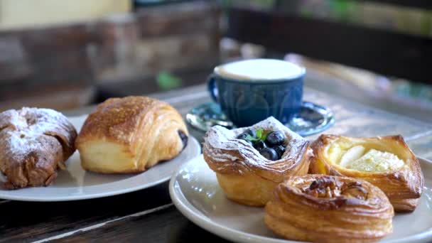 Zoet gebak. Verse smakelijke bakkerij op borden en kopje koffie, Morning sweet food — Stockvideo