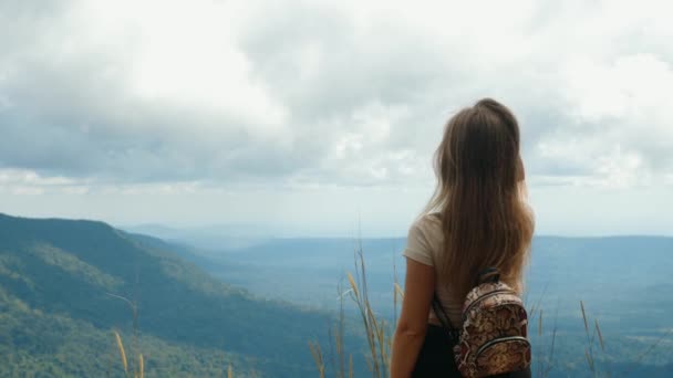 Viaje de inspiración. Vista trasera de la mujer con la mochila de pie en la cima de la montaña — Vídeo de stock