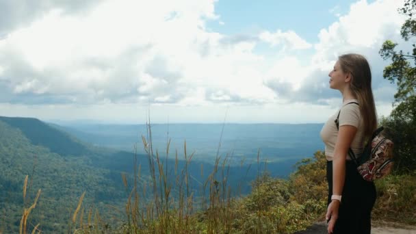Inspirovaný cestovní žena s batohem stojí na vrcholu hory, otevřené paže, dýchá — Stock video