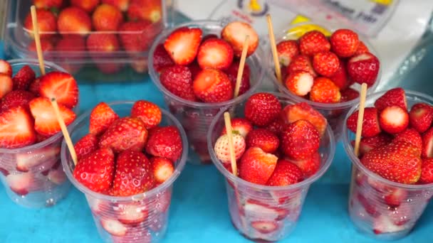 Plastic bekers met verse rode aardbeien op fruitmarkt. Lokale boerenmarkt — Stockvideo