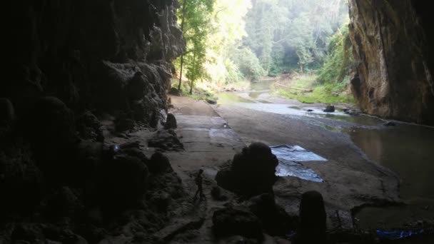 Kvinnan utforskar grottan, grottutforskning. Resenär upptäcktsresande promenad i mörk grotta — Stockvideo