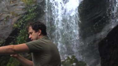 Şelalede fotoğrafçı ormandaki doğa ve manzarayı çekiyor.