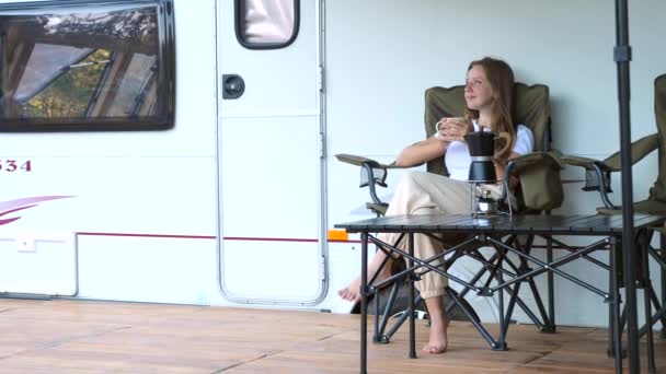 Belle jeune femme relaxante et regardant près du camping-car — Video
