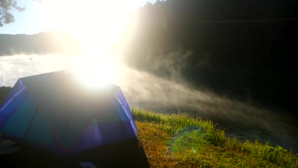 Tienda de campaña cerca de niebla río en el fondo de la naturaleza con salida del sol vista panorámica — Vídeo de stock