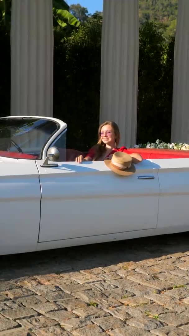 VERTICAL VIDEO podróży retro kobieta uśmiechnięta szczęśliwy w starym białym rocznika samochodu — Wideo stockowe