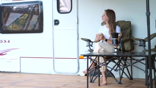 Szczęśliwa kobieta siedząca przed klasycznym vanem, pijąca kawę. Podróżować po świecie — Wideo stockowe