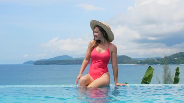 Женщина на тропическом отдыхе расслабиться в бассейне в роскошном отеле с океаном — стоковое видео