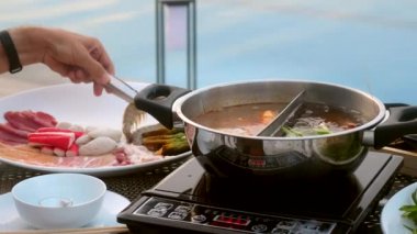 Nehir karidesini al ve Shabu Shabu usulü kaynayan tencereye koy.