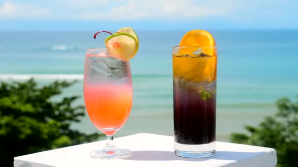 Dos cócteles tropicales en la mesa con vistas al mar para las vacaciones de verano — Vídeos de Stock