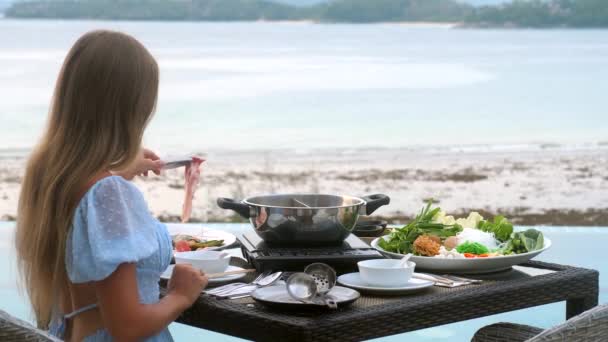 Vrouw koken shabu shabu in hete pot op kachel in Japans restaurant met zee — Stockvideo