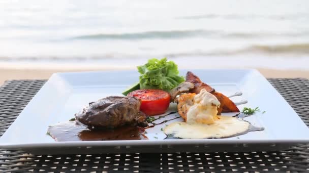 Talíř filet mignon hovězí steak na pláži stolu v resortu restaurace s mořskou vlnou — Stock video