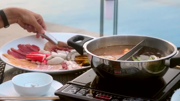 沙布沙布或寿司肉、牛肉和海鲜在靠近锅边的沸腾火锅中 — 图库视频影像