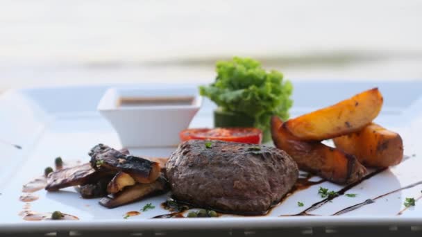 Filet mignon beef steak on beach table in luxury resort outdoors restaurant — Stock Video