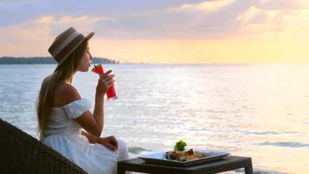 Vrouwelijke toeristische drank fruit watermeloen smoothie, kijk naar prachtig uitzicht op zee — Stockvideo