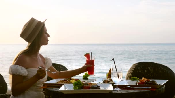 Романтическая девушка обедать в тропическом ресторане курорта на пляже, морской фон — стоковое видео