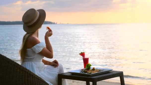 Luxury sea resort καλοκαιρινές διακοπές έννοια, γυναίκα στο εστιατόριο κατά τη διάρκεια του ηλιοβασιλέματος — Αρχείο Βίντεο