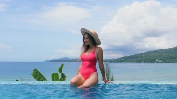 Νεαρή γυναίκα χαλαρώνει στην πισίνα στις καλοκαιρινές διακοπές. Τροπικές διακοπές — Αρχείο Βίντεο
