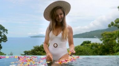 Mayolu seksi genç kadın rahatla, güneşlen ve jakuzide tatilin tadını çıkar.