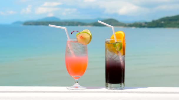 Two glasses of chilled non-alcoholic tasty tropical cocktails with ocean — Stock Video
