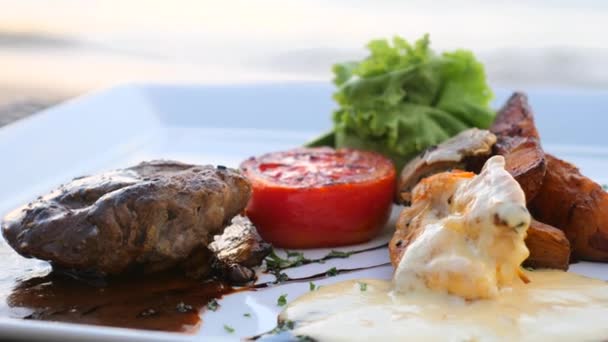 Primer plano de filete a la parrilla mignon carne de res en el restaurante del complejo en la mesa de playa — Vídeo de stock