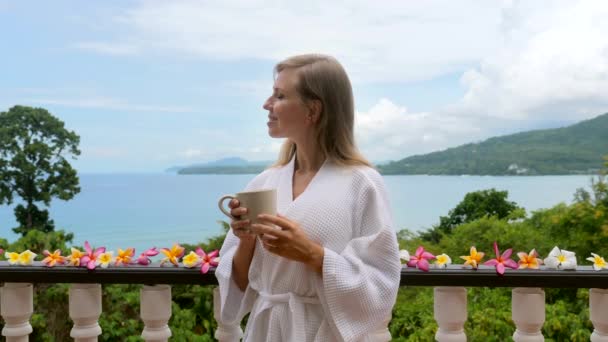 Szczęśliwy podróżnik kobieta w szlafroku odpocząć i cieszyć się widokiem na morze na wyspie Phuket — Wideo stockowe