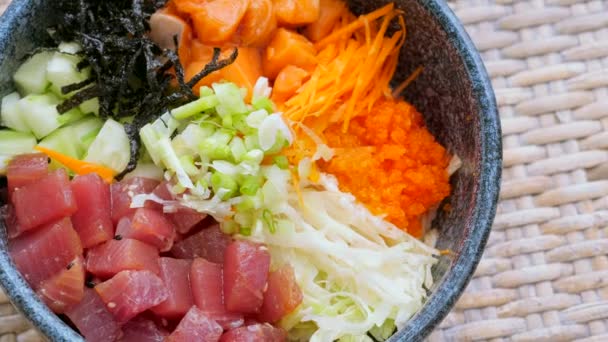 Zbliżenie Hawajskie danie poke bowl z pokrojonym w kostkę surowego łososia i tuńczyka — Wideo stockowe