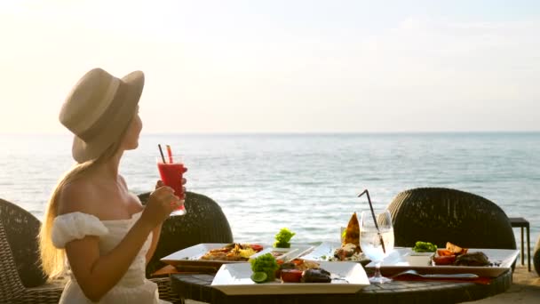 Junge Frau frühstückt romantisch bei Sonnenaufgang im Restaurant des Resorts — Stockvideo