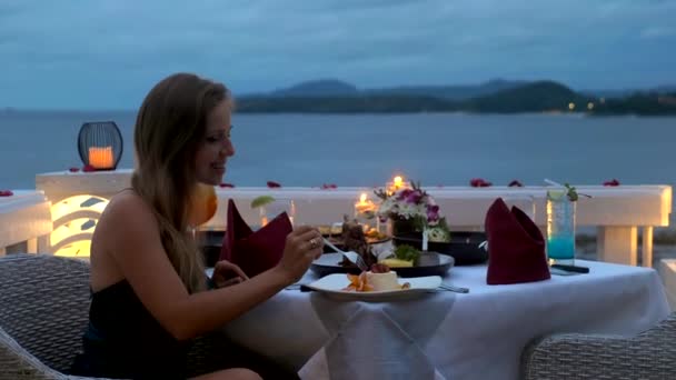 Ευτυχισμένη νεαρή γυναίκα απολαύσετε ρομαντικό δείπνο με κεριά στο πολυτελές εστιατόριο του ξενοδοχείου — Αρχείο Βίντεο