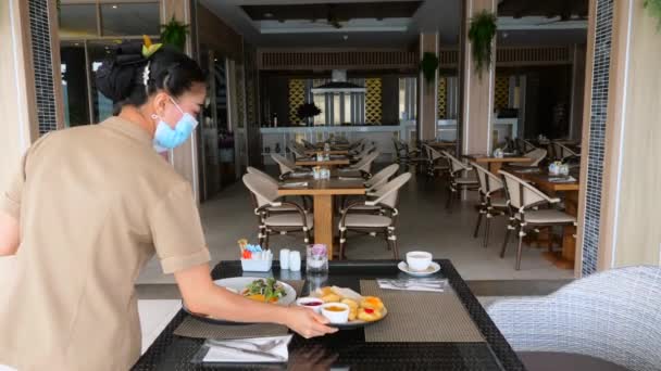 Asiatische Kellnerin Mit Schützender Gesichtsmaske Serviert Frühstücksmahlzeiten Hotel Resort Restaurant — Stockvideo