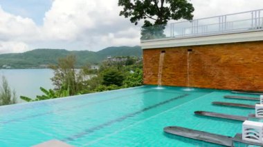 Modern tropik tatil beldesinde küçük şelaleleri olan yüzme havuzu.