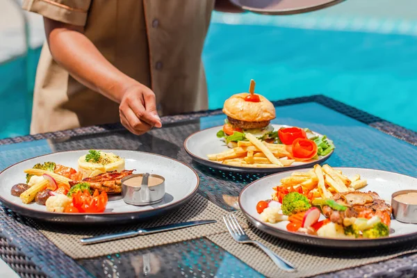 Camarera mano que sirve el almuerzo en el restaurante en el hotel, vacaciones, concepto de vacaciones — Foto de Stock