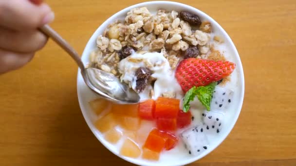 Woman hand with spoon eat bowl of homemade granola with yogurt and fresh berries — Stok Video