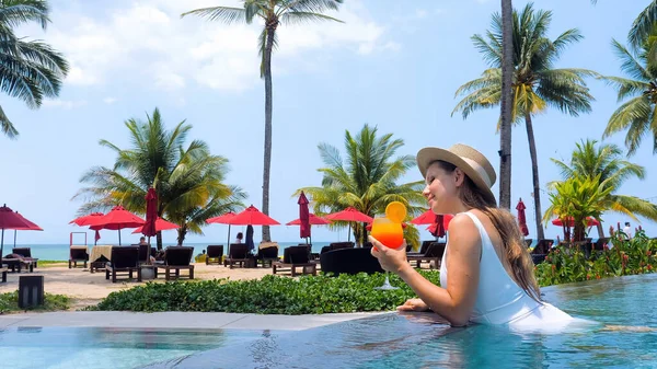 Woman in resort near beach at hot sunny day drinking refreshment cocktail — Stock Fotó