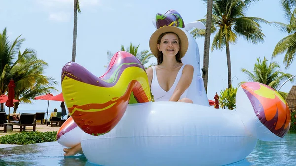 Happy woman in swimwear fun and relax on floaties inflatable unicorn mattress — Zdjęcie stockowe