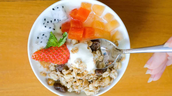 Woman hand with spoon eat bowl of homemade granola with yogurt and fresh berries — Stock Photo, Image