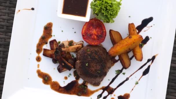 Tenderloin beef steak, grilled vegetables, demi-glace sauce on white plate — Vídeos de Stock