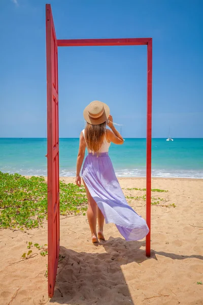 Tropische reisvakantie. Reiziger vrouw in rode deur op het strand naar turquoise zee — Stockfoto