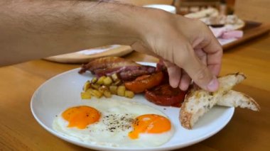 Adam kahvaltıda ya da öğle yemeğinde kızarmış yumurta sarısına batırılmış ekmek yiyor.