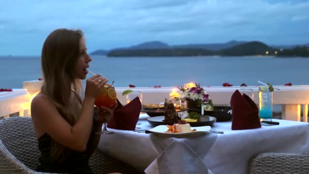 Γυναίκα σε σέξι βραδινό φόρεμα γουλιά κοκτέιλ μέσω άχυρο στο πολυτελές εστιατόριο του ξενοδοχείου — Αρχείο Βίντεο