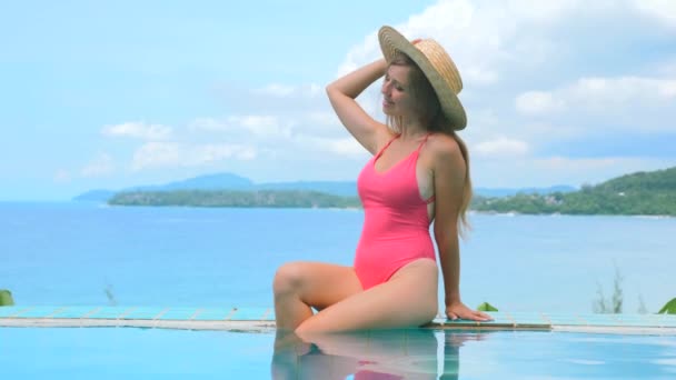 Mulher de fato de banho vermelho e chapéu relaxante na piscina exterior em Phuket — Vídeo de Stock