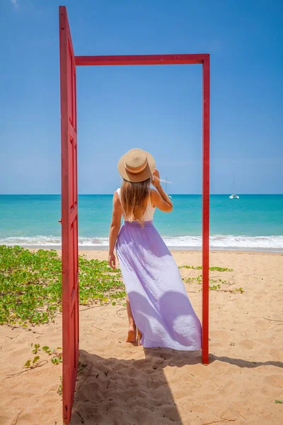 Tropische reisvakantie. Reiziger vrouw in rode deur op het strand naar turquoise zee — Stockfoto