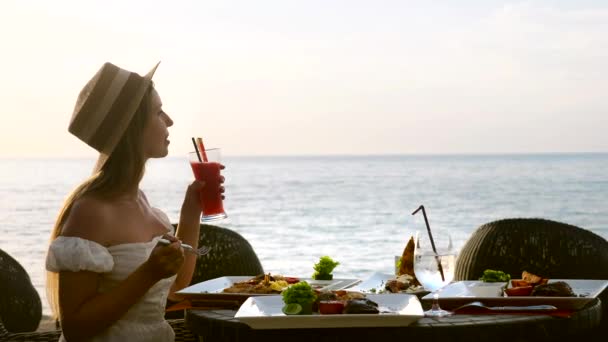 Γυναίκα τουρίστρια ματιά στη θάλασσα, να απολαύσετε τις διακοπές, να φάτε δείπνο σερβίρεται στο θέρετρο — Αρχείο Βίντεο