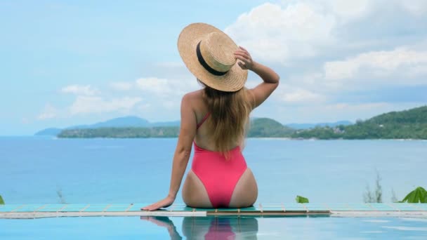 Visão traseira da jovem alegre sexy em roupa de banho rosa na piscina — Vídeo de Stock
