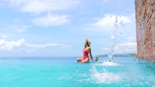 Vrouw in badmode en strohoed ontspannen in het zwembad in luxe hotel spa — Stockvideo