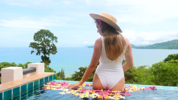 Lüks seyahat tatili. Otel jakuzisinde tropik çiçekli bir kadın. — Stok video
