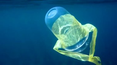 Okyanustaki Plastik Kirliliği. Plastik kokteyl bardağı tropikal denizde yüzüyor. Çevresel bir sorun. Kirlilik tehlikesi. Geri dönüşüm çöpleri, plastik çöpler önemli.