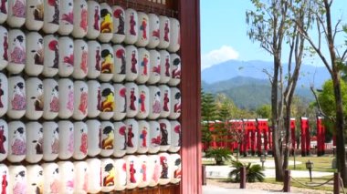 Geleneksel Japon kağıt fenerleri arka planda dağlarla birlikte bahçede asılı duruyor. Japon Chochin feneri ve kadın resimleri.