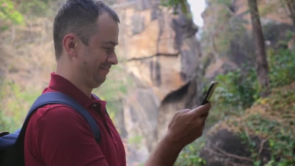 Glücklicher Mann Mit Rucksack Nationalpark Der Auf Sein Handy Schaut — Stockvideo